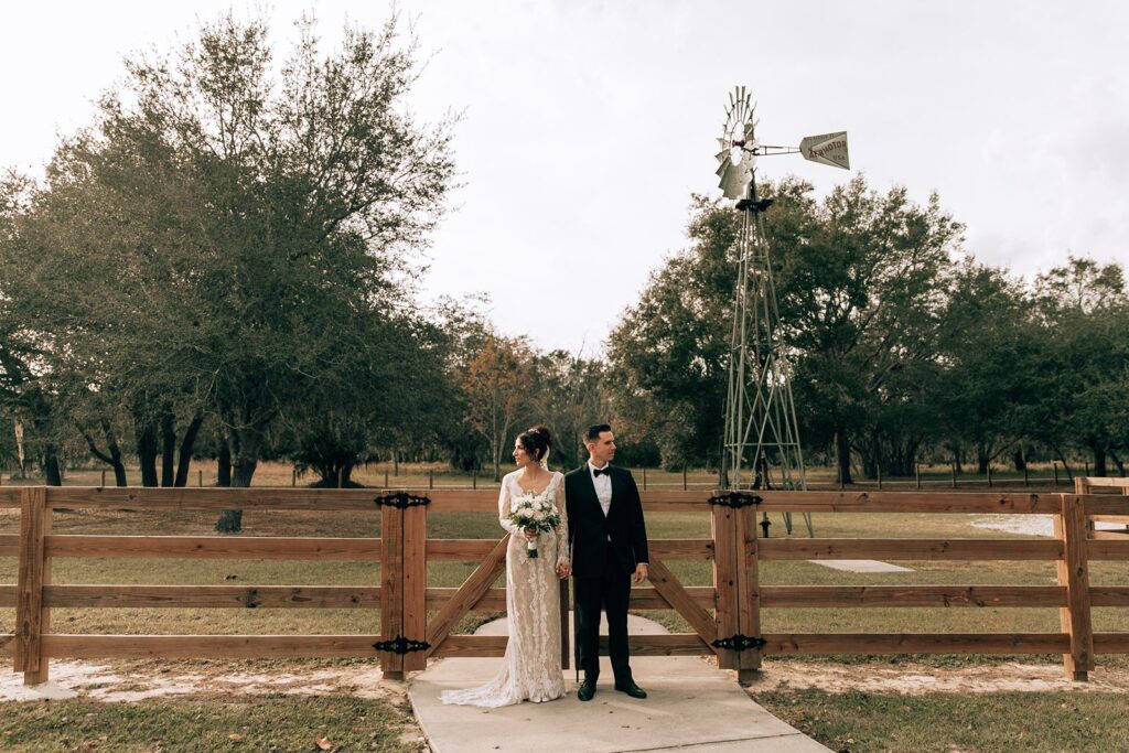 bride and groom portrait with a windmill at chapel valley farm