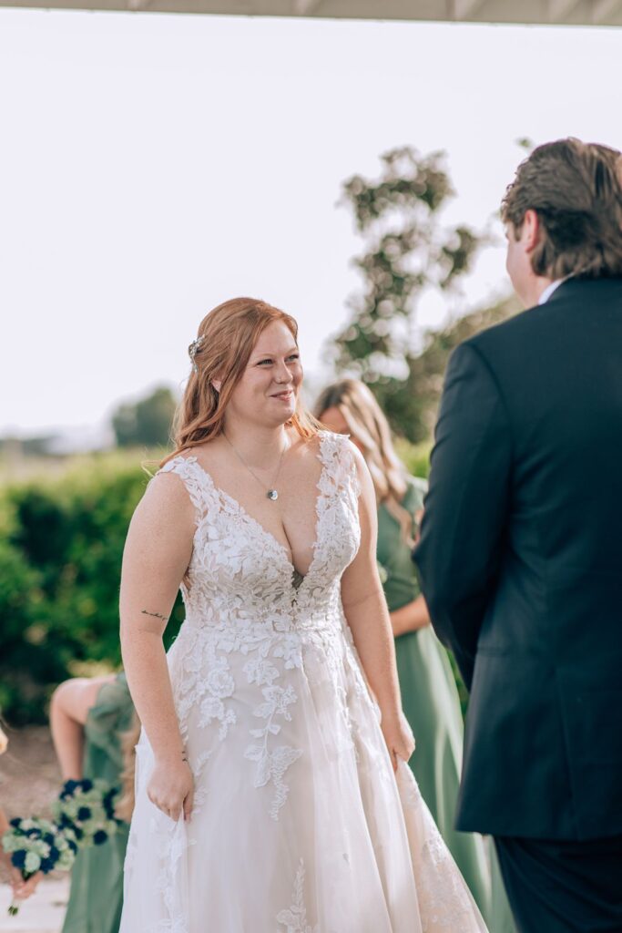 bride smiles in excitment as she reaches the end of the aisle to marry her groom