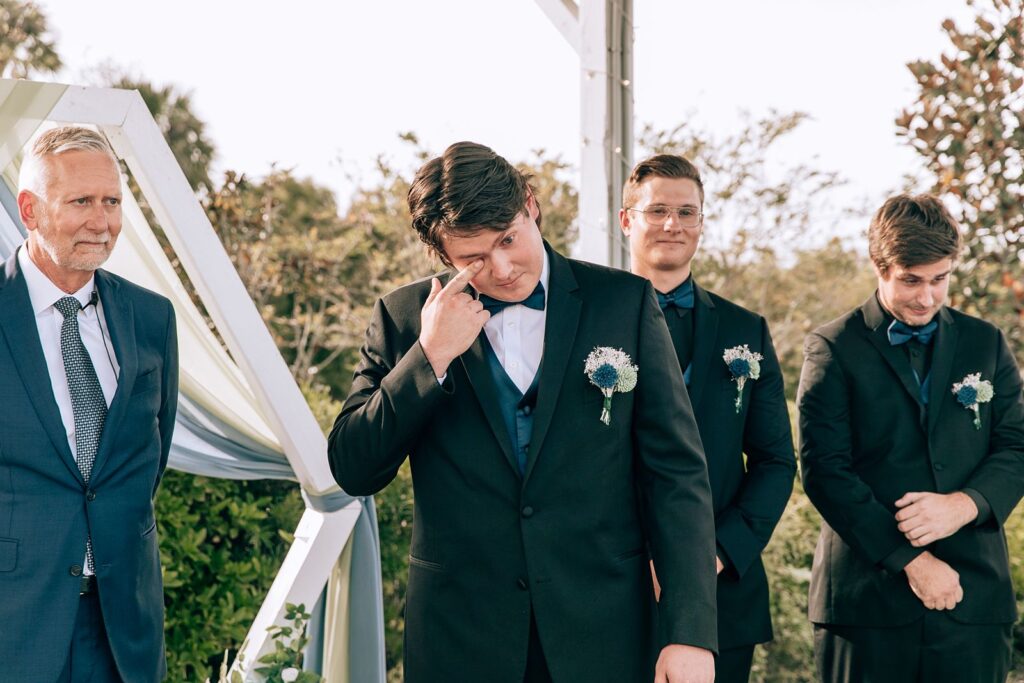groom crys while he watches his bride walk down the aisle