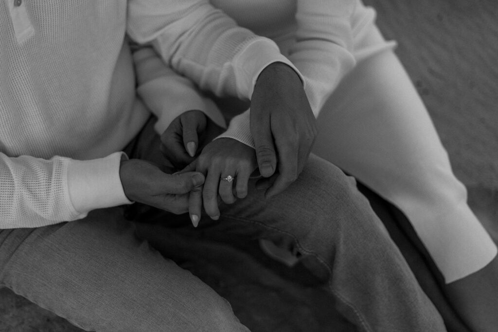 black and white detail photos of groom holding brides hand to show off her engagement ring